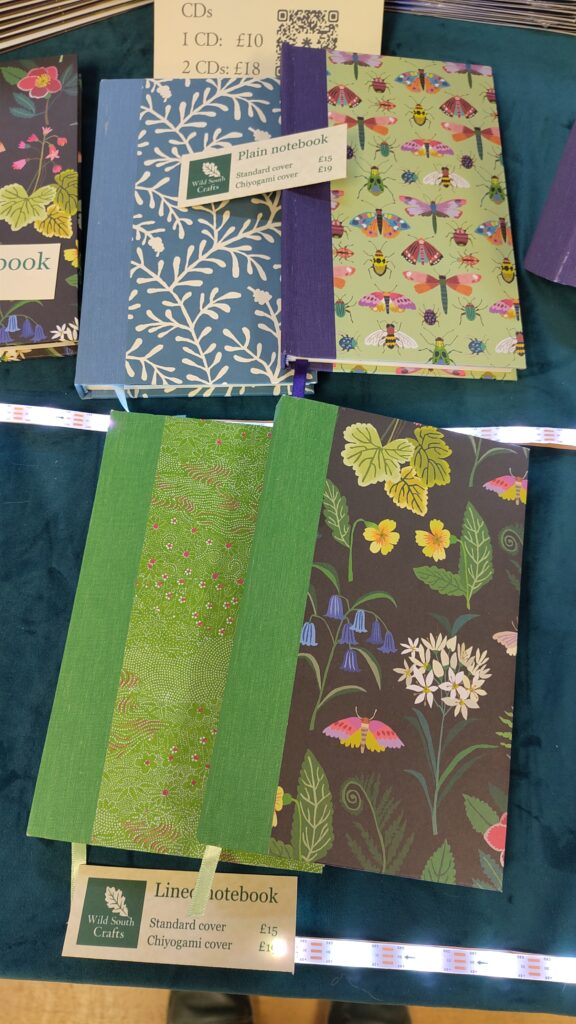 Picture of four notebooks: bottom left: chioyogami paper; bottom right woodland wildflowers, top left: blue sprig; top right: insects